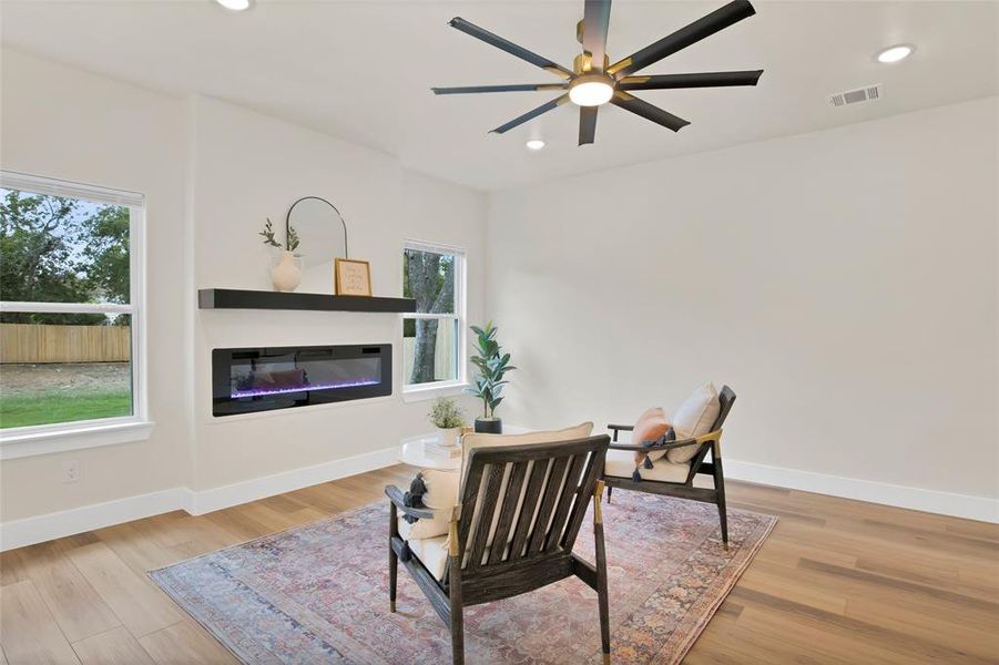 Living area with ceiling fan, plenty of natural light, and light hardwood / wood-style flooring