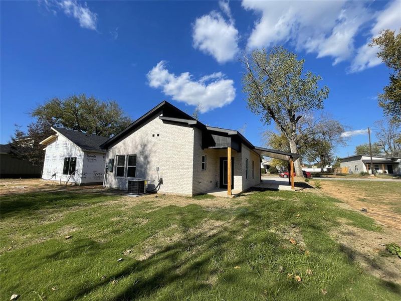 View of home's exterior featuring cooling unit, a yard, and a patio area