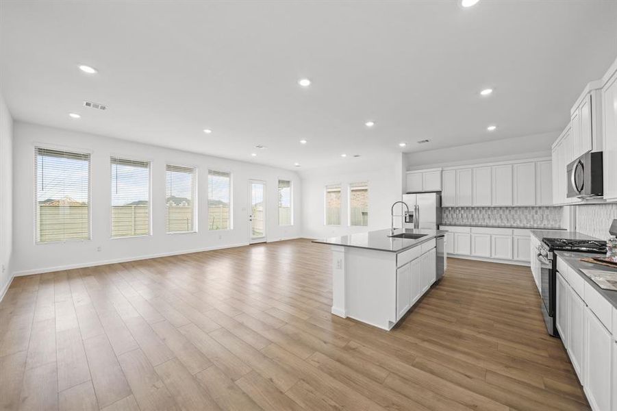 Windows galore in this open floorplan overlooking this kitchen to the covered patio in the backyard. Wood Blinds and recessed lighting throughout.