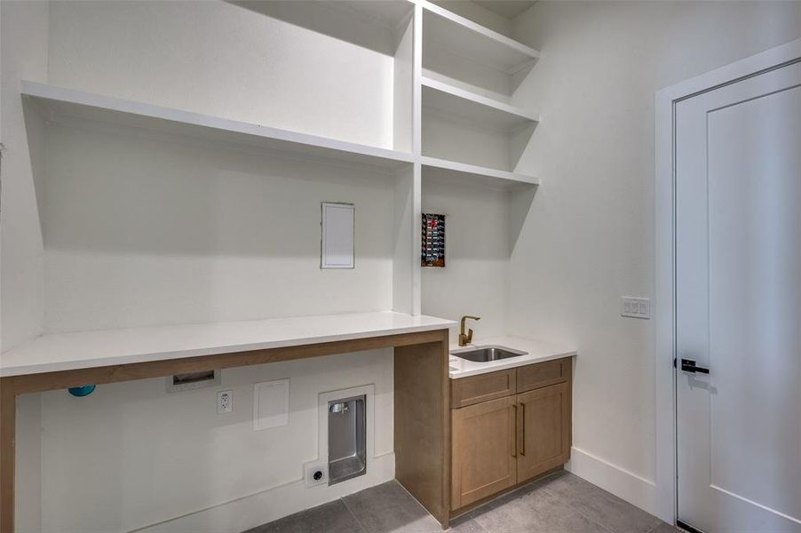 Laundry room featuring cabinets, sink, and light tile patterned floors