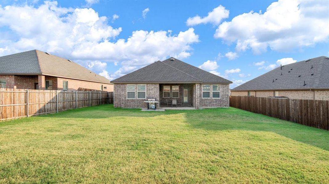 Rear view of property featuring a patio area and a lawn