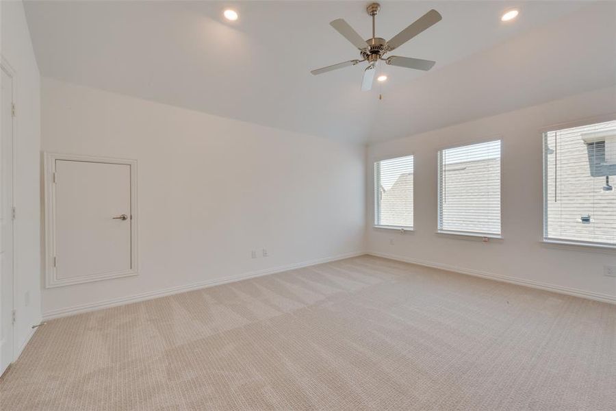 Unfurnished room featuring lofted ceiling, light carpet, and ceiling fan