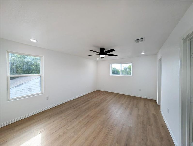 Unfurnished room with light hardwood / wood-style floors, plenty of natural light, and ceiling fan