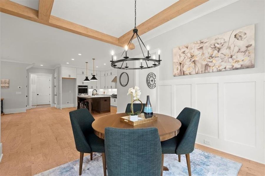 Dining space featuring light hardwood / wood-style floors, sink, crown molding, and a notable chandelier