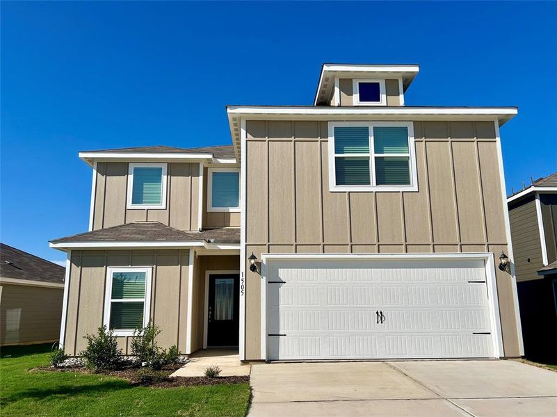 View of front of property with a front yard and a garage