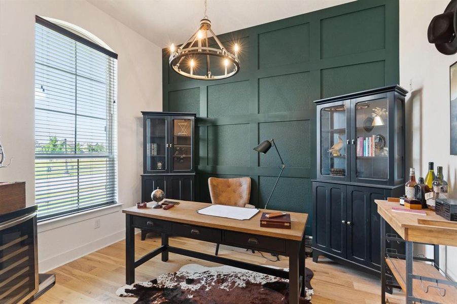 Office area featuring wine cooler, a chandelier, and light hardwood / wood-style floors