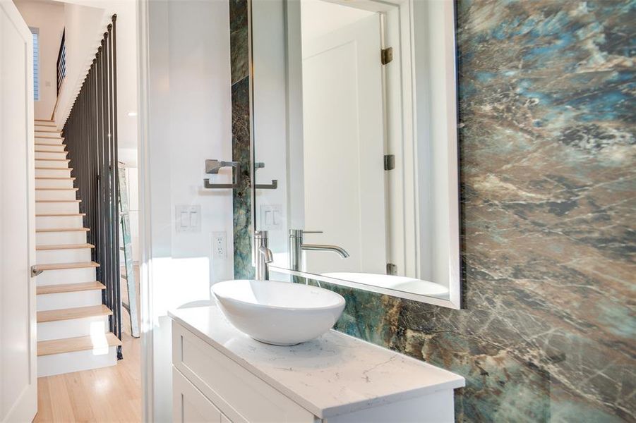 Bathroom with vanity, hardwood / wood-style floors, and decorative backsplash