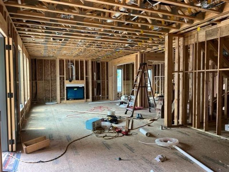 View from kitchen looking towards the living and dining area. Progress photo take 4.18.24. To the left is a door leading to covered patio and backyard.