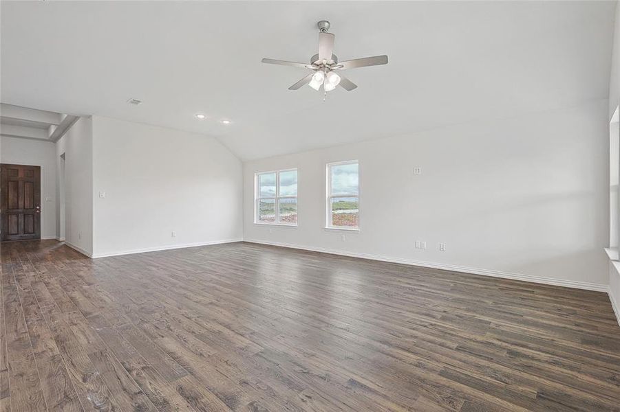 Unfurnished room featuring lofted ceiling, ceiling fan, and dark hardwood / wood-style floors