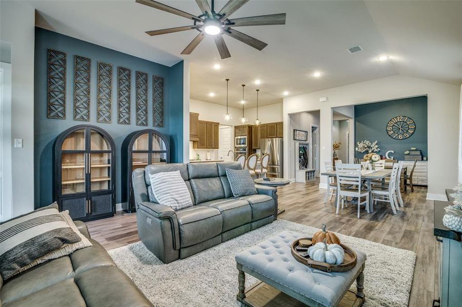 Living room with light wood-type flooring, lofted ceiling, and ceiling fan