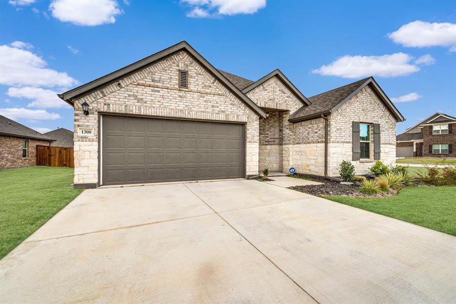 View of front of property featuring a front yard and a garage