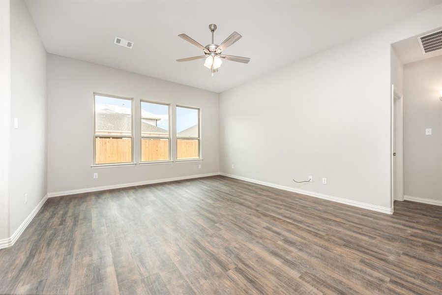 Empty room featuring dark hardwood / wood-style floors and ceiling fan