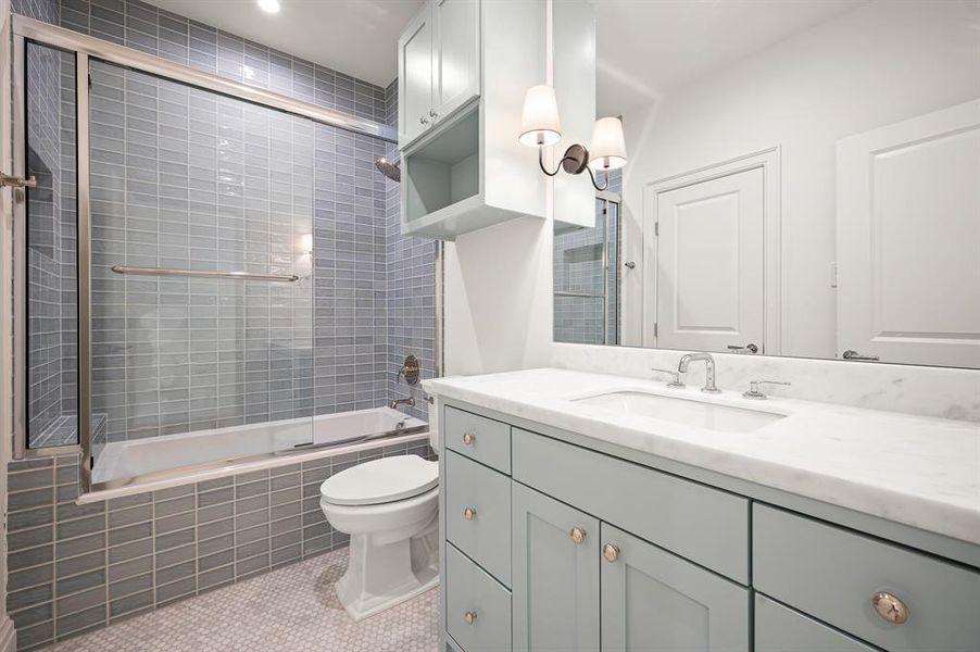 Full bathroom featuring vanity, tile patterned floors, enclosed tub / shower combo, and toilet