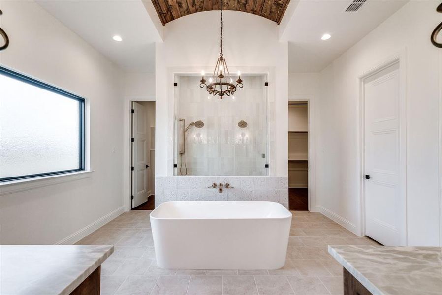 Bathroom featuring plus walk in shower, tile patterned floors, a chandelier, and vanity