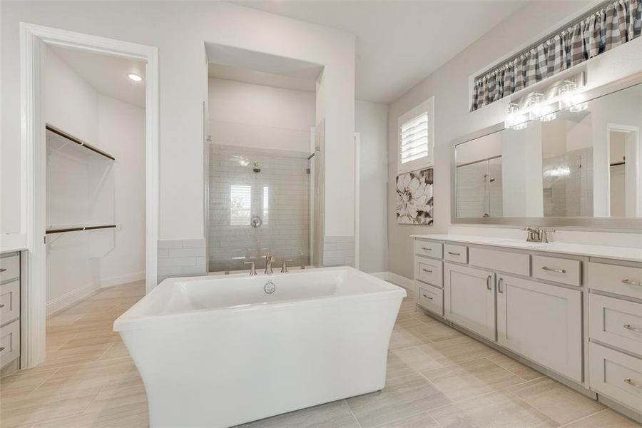 Bathroom featuring independent shower and bath, separate vanities, and tile patterned floors