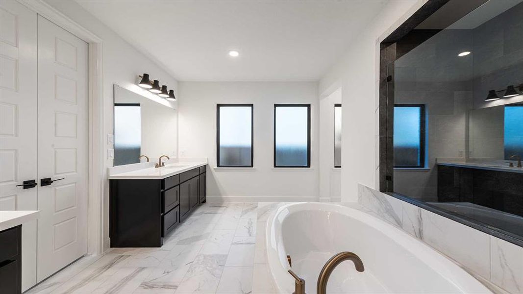 Bathroom featuring vanity and shower with separate bathtub