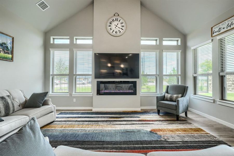 Living room featuring high vaulted ceiling, hardwood / wood-style floors, and plenty of natural light