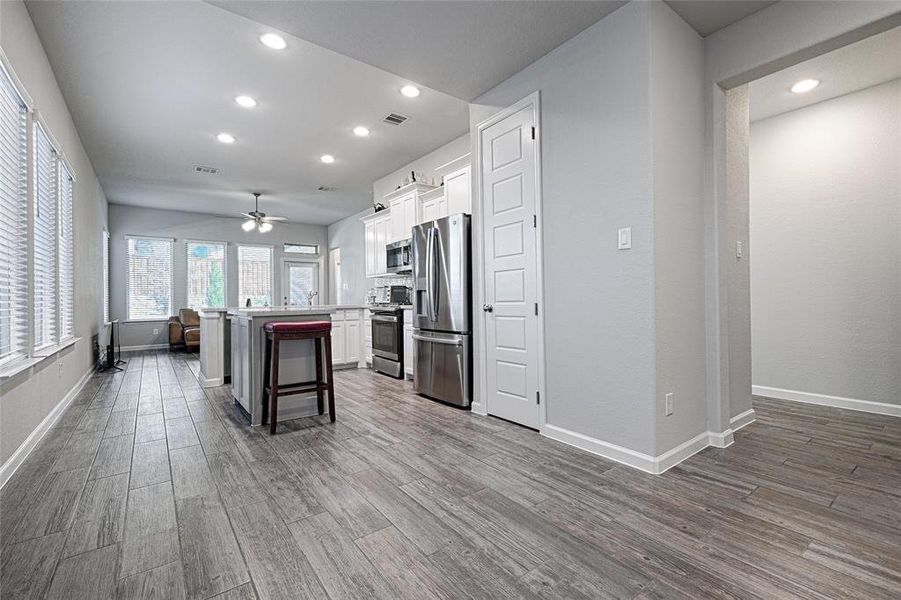 Kitchen with stainless steel finishes, white cabinetry, a breakfast bar, a center island, gas cooktop