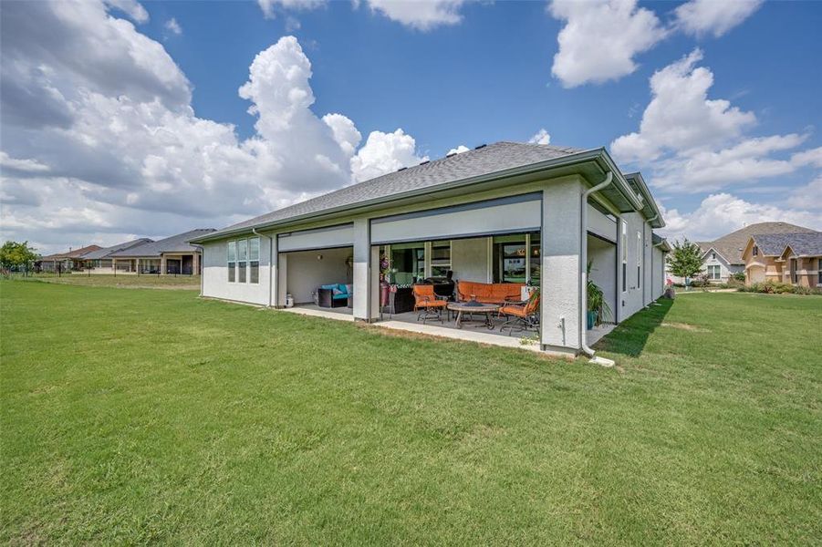 Rear view of property with screened patio area and a lawn