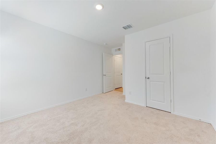 Unfurnished bedroom featuring light colored carpet