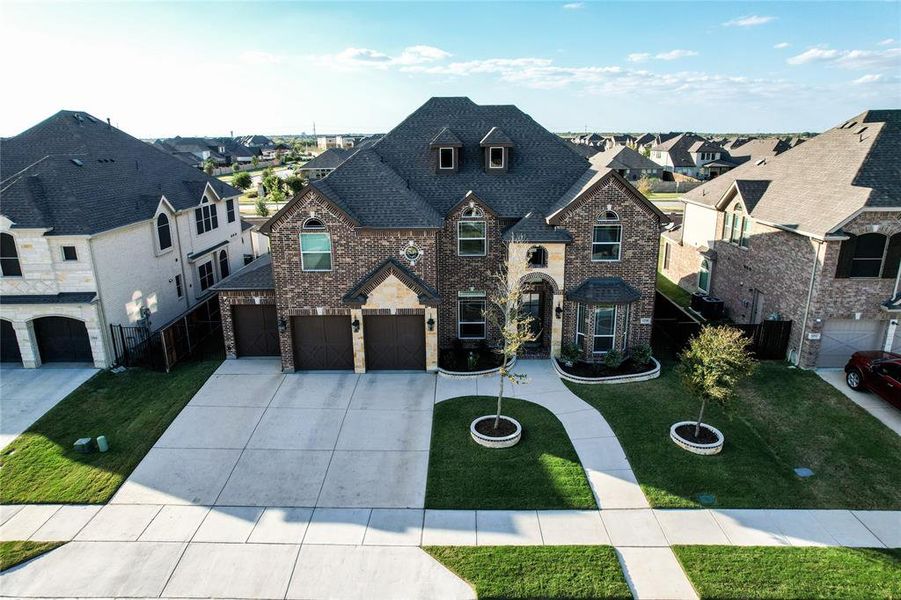 French provincial home with a garage and a front lawn