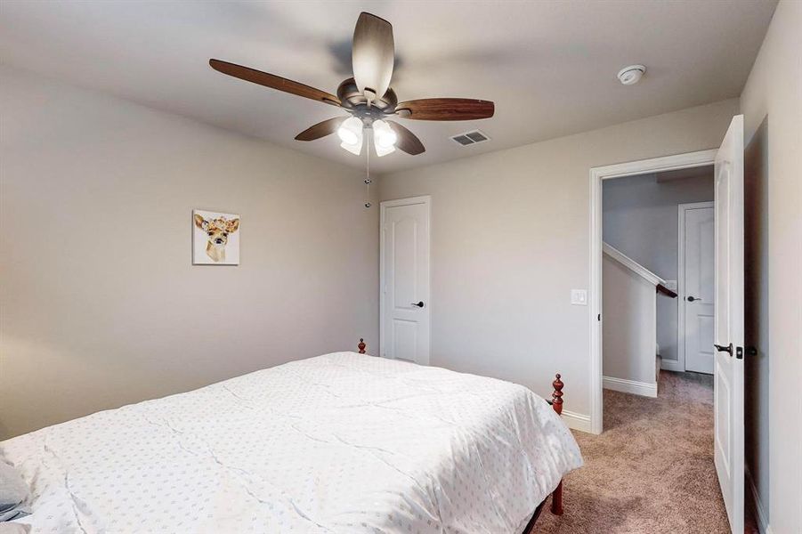 Carpeted bedroom featuring ceiling fan