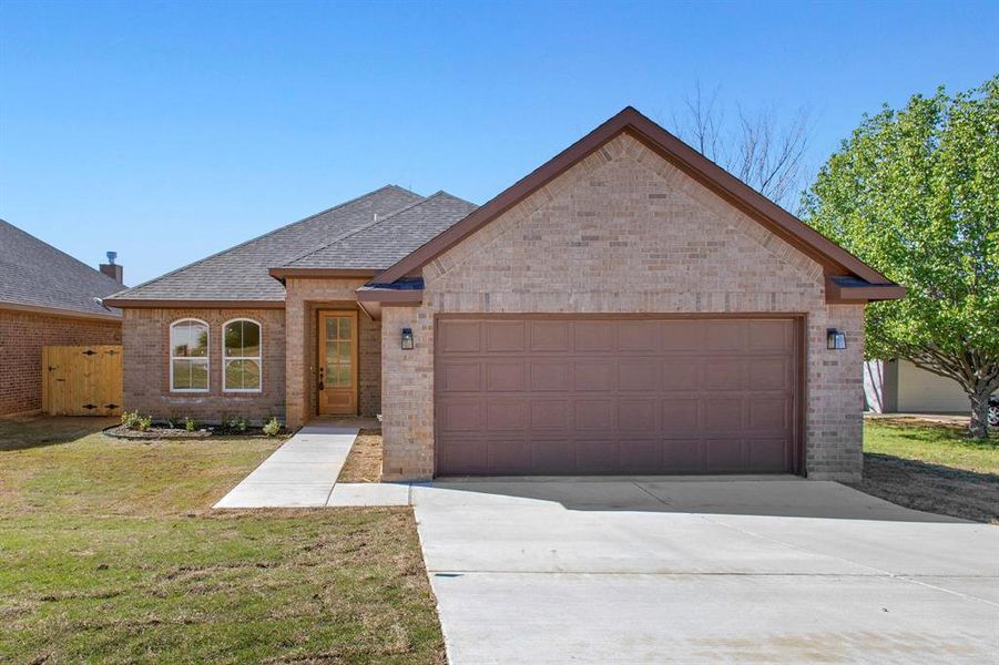 View of front of house with a garage and a front yard