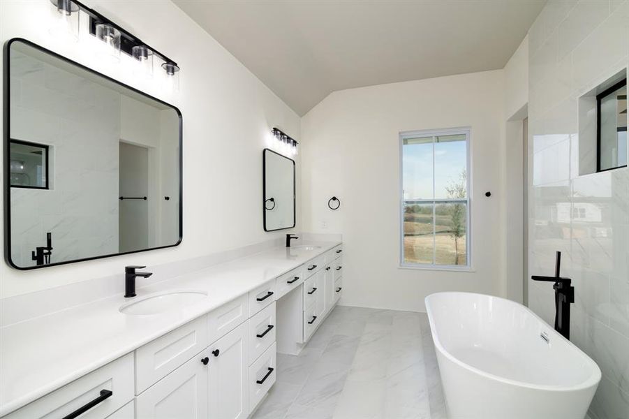 Bathroom with a bath, tile floors, dual vanity, and tile walls