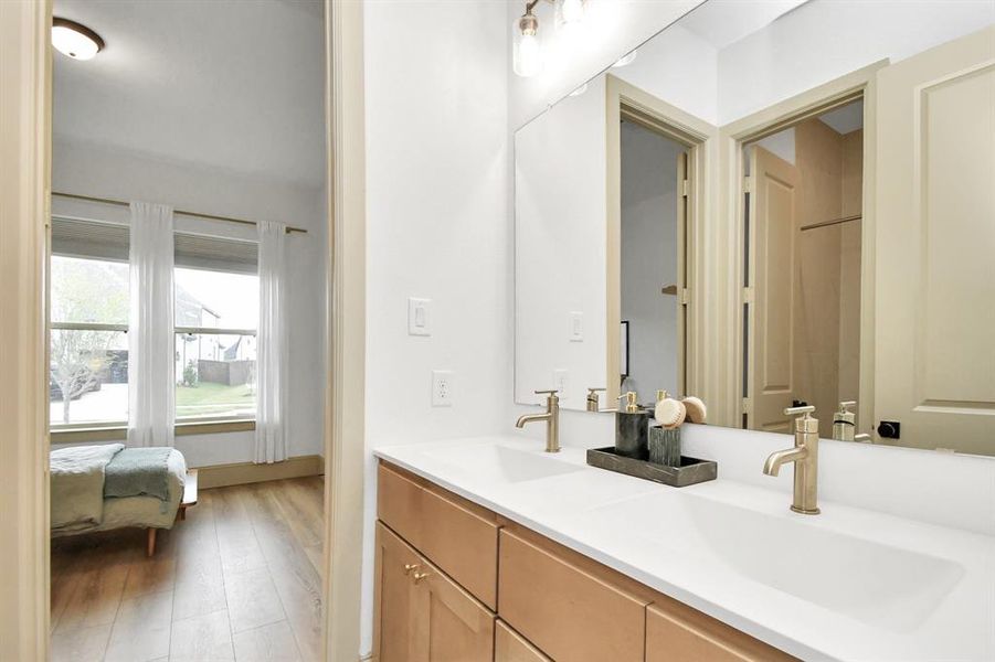 Jack and Jill bathroom between bedrooms 1 & 2 - featuring dual sinks with beautiful brass fixtures and private toilet and tub shower.