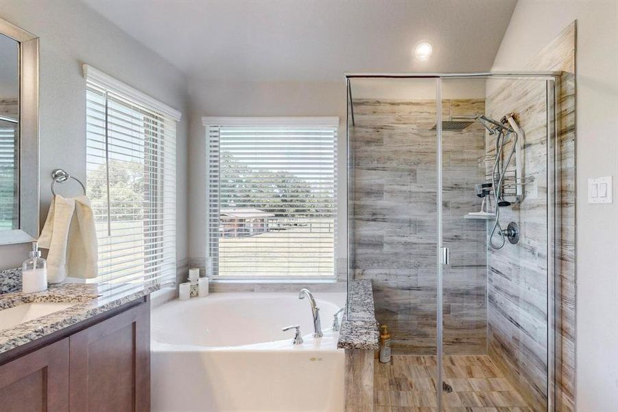 Bathroom with plus walk in shower, vanity, and plenty of natural light