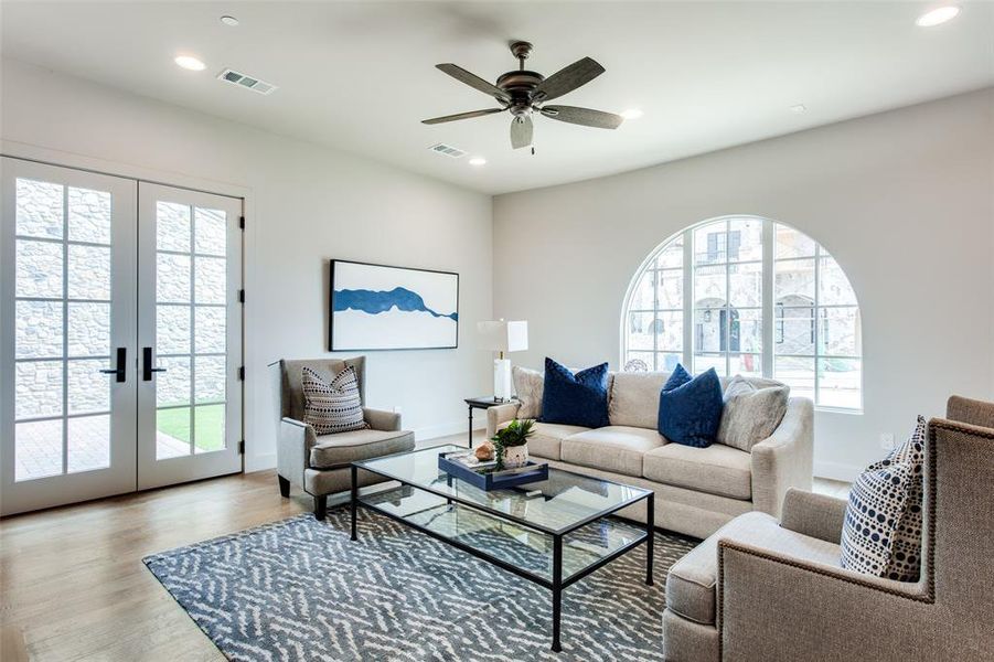 Living room with hardwood / wood-style flooring, french doors, and ceiling fan