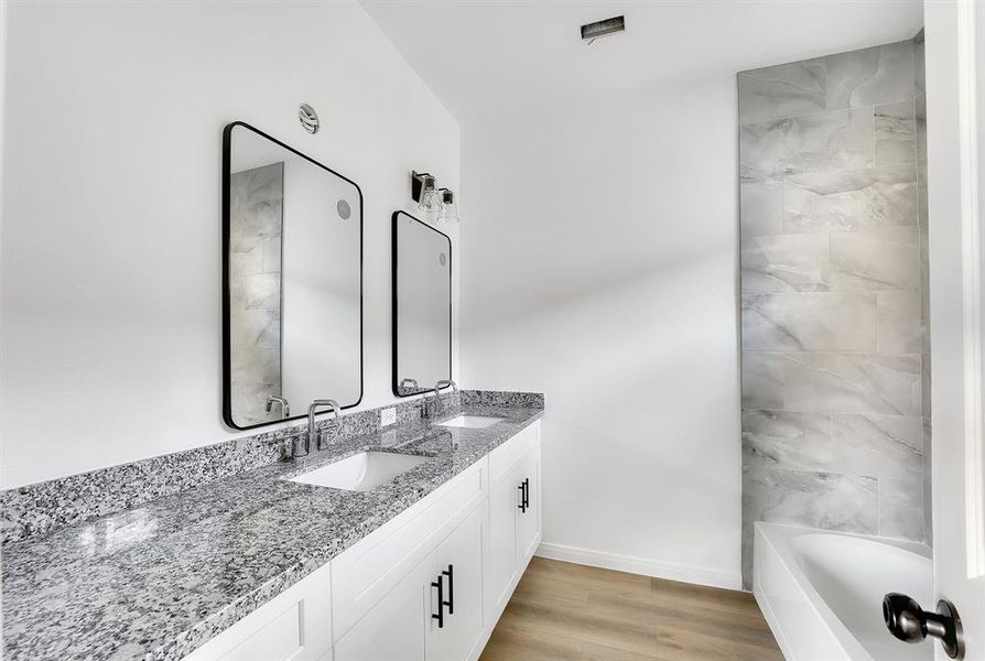 Master Bathroom - The master bathroom boasts a modern design with dual sinks, a tub, and ample counter space.