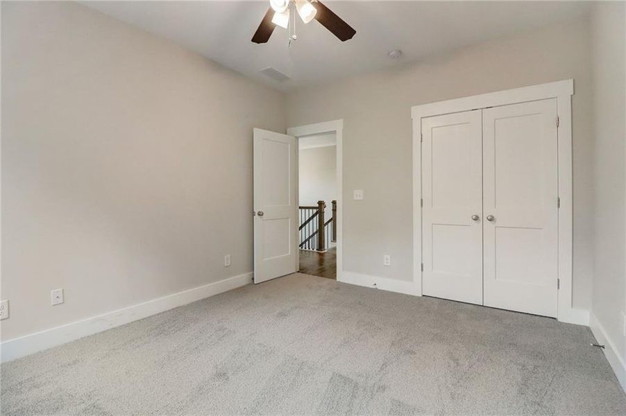 Unfurnished bedroom with a closet, ceiling fan, and light colored carpet