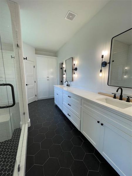 Bathroom featuring vanity, tile patterned floors, and walk in shower