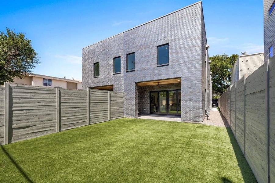 Rear view of house featuring a patio and a lawn