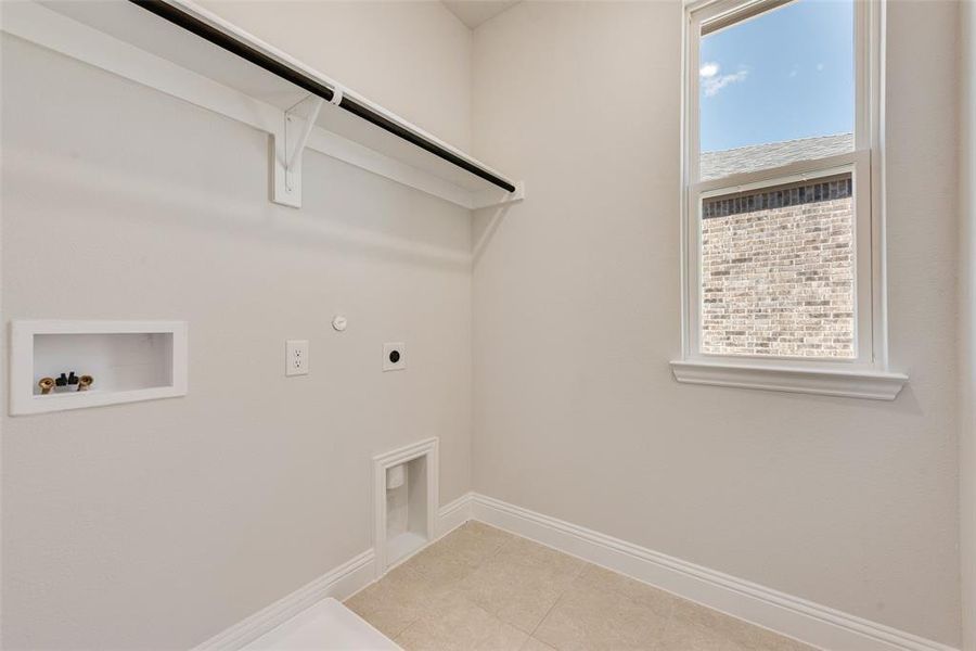 Laundry area with gas dryer hookup, hookup for an electric dryer, plenty of natural light, and hookup for a washing machine