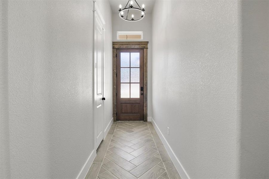 Doorway to outside with a notable chandelier