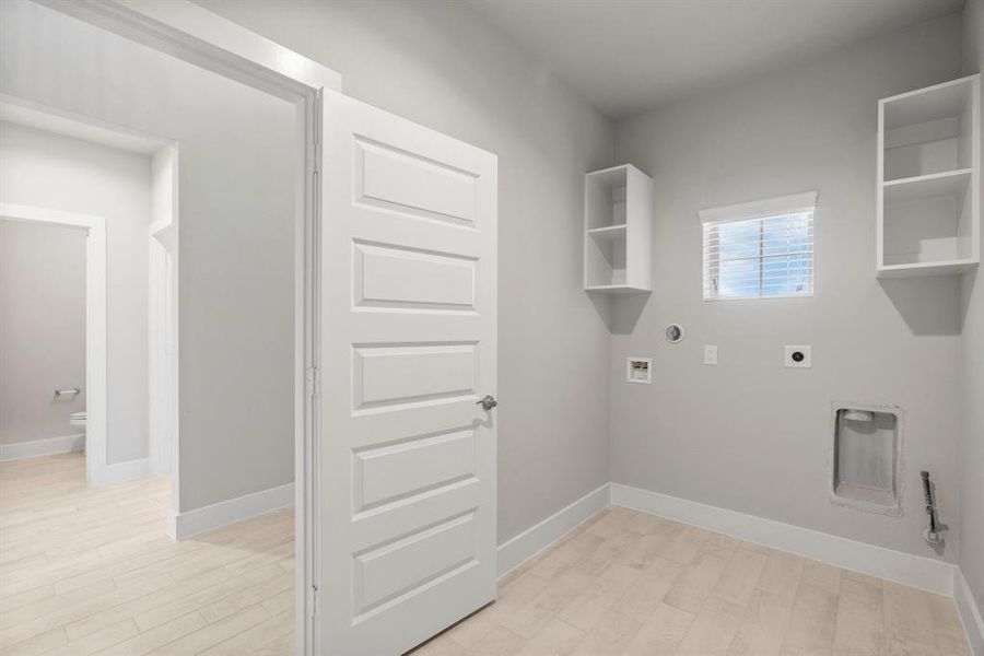 A perfect blend of functionality and comfort. Capture the essence of easy living with a first-floor laundry room, thoughtfully equipped with shelving for effortless organization. Sample photo of completed home with similar floor plan. Actual colors and selections may vary.