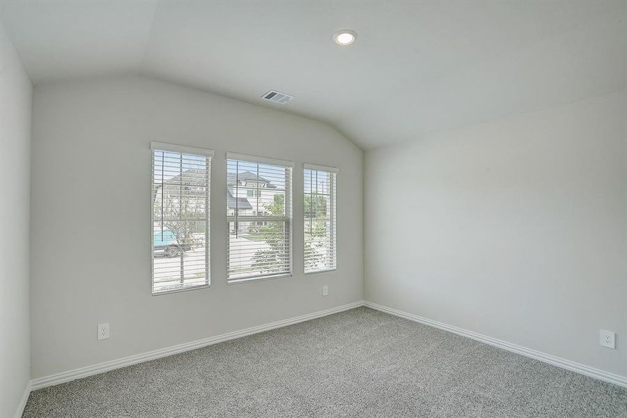 Bedroom with lofted ceiling and carpet