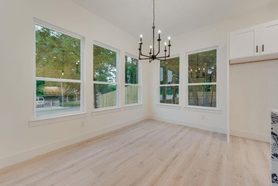 Unfurnished dining area with light hardwood / wood-style flooring and a wealth of natural light