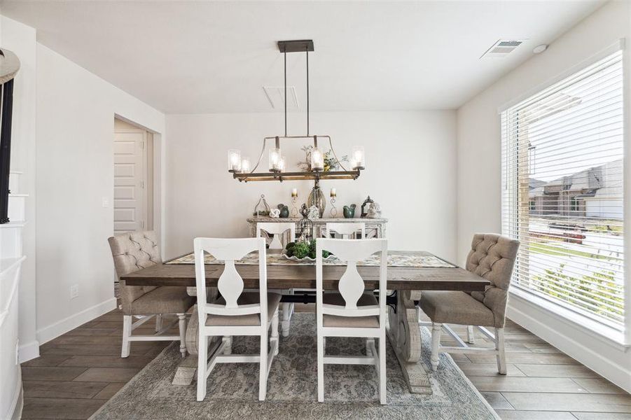 The formal dining room offers tile floor and a large window overlooking the front lawn.