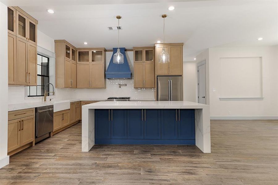 Spacious island kitchen with Quartz countertops and custom cabinetry and drawers with decorative pulls