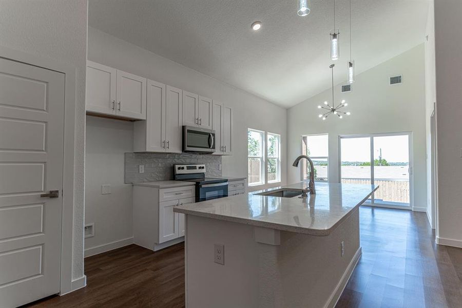 Kitchen with island sink and electric range