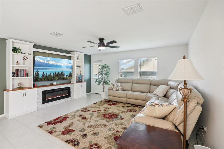 Living room featuring light tile patterned flooring and ceiling fan