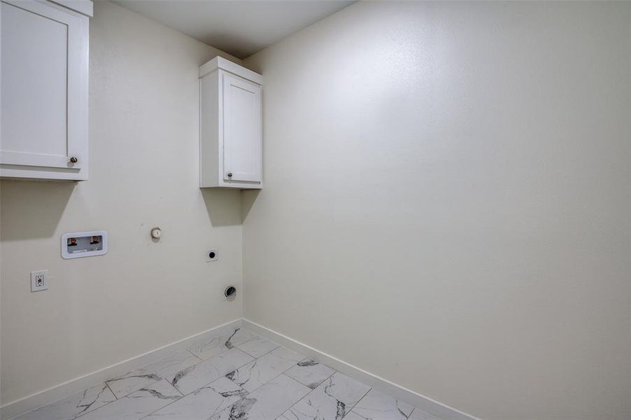 Washroom with washer hookup, cabinets, hookup for an electric dryer, and gas dryer hookup