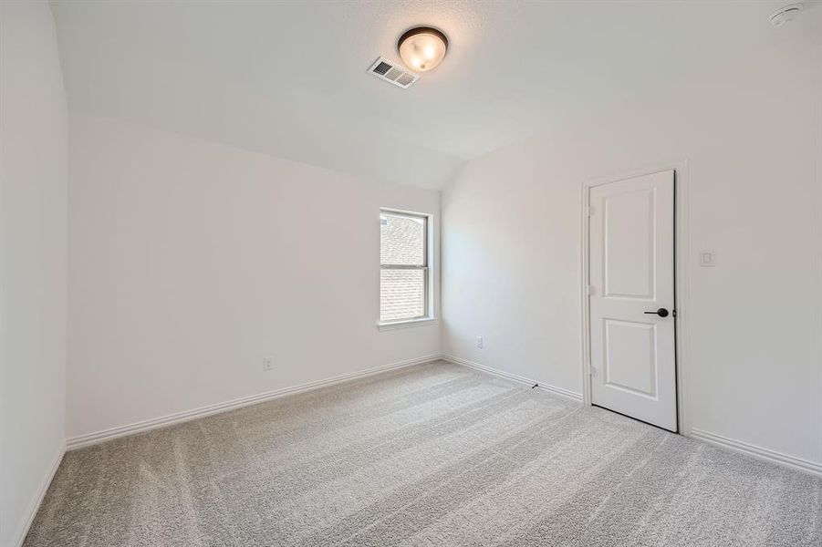 Carpeted spare room with lofted ceiling