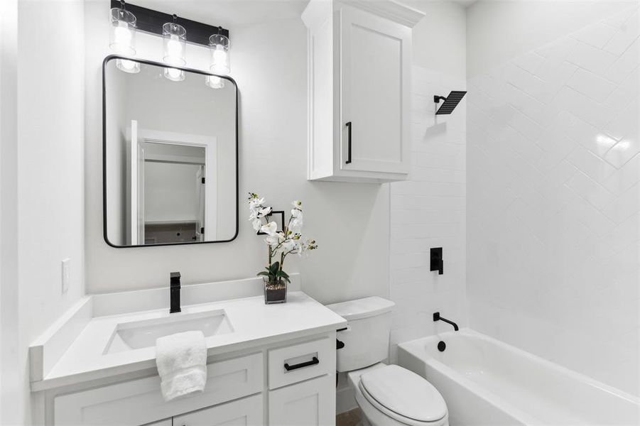 Full bathroom with vanity, toilet, and tiled shower / bath combo