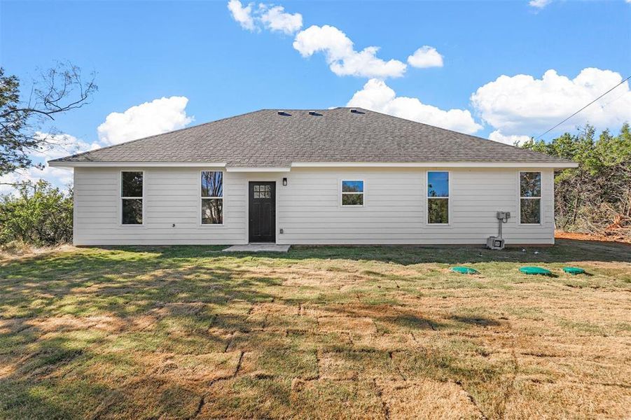 Back of house with a lawn