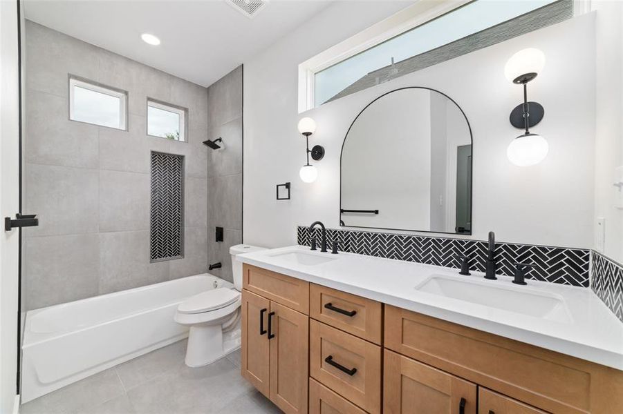 A secondary bathroom with a tub and shower combo provides flexibility and convenience, allowing users to choose between a quick shower or a relaxing bath, making it suitable for various preferences and needs. Has double sinks.