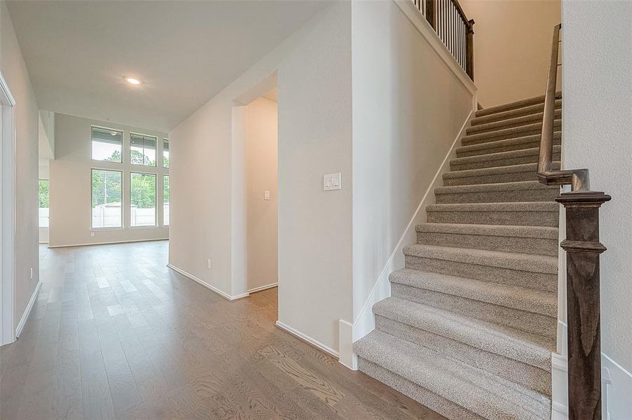 Luxury vinyl wood-look flooring graces the first level, while plush carpet adds comfort to the stairs and bedrooms.